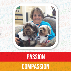 Mary Lou Turner smiles while holding her two therapy dogs, Muffie and Gracie