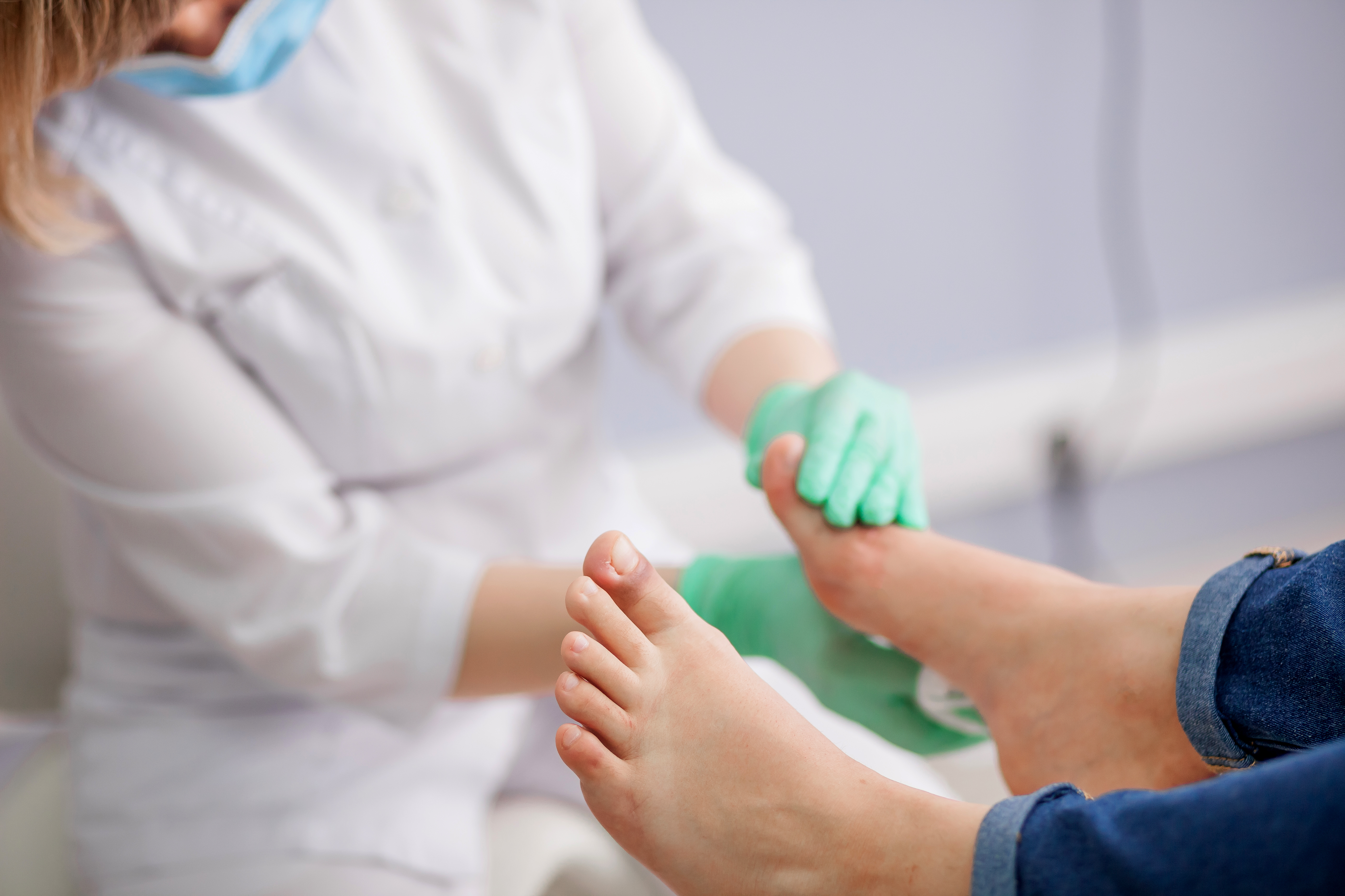 A health care provider examines a patient's feet