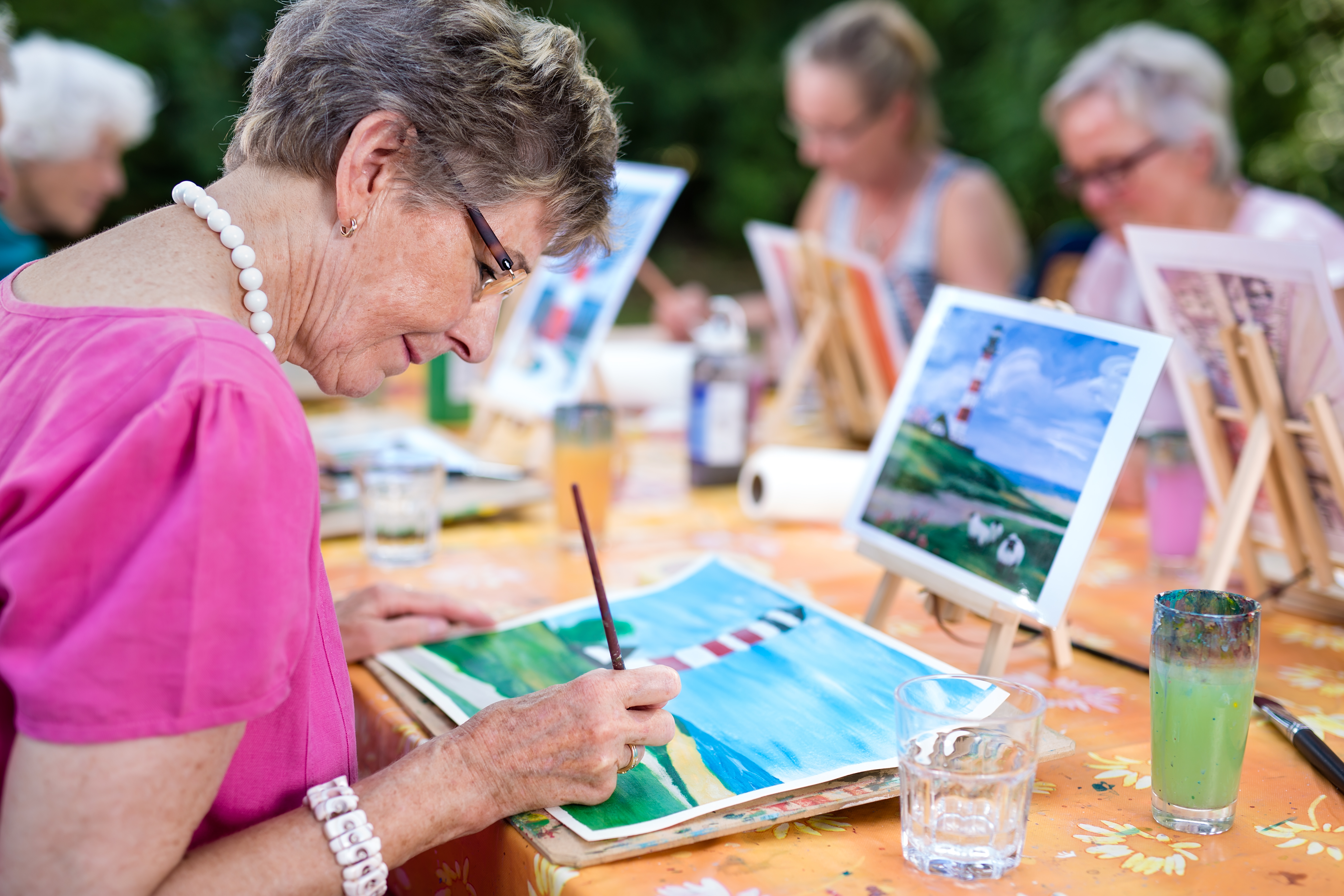 seniors enjoy painting together at a table